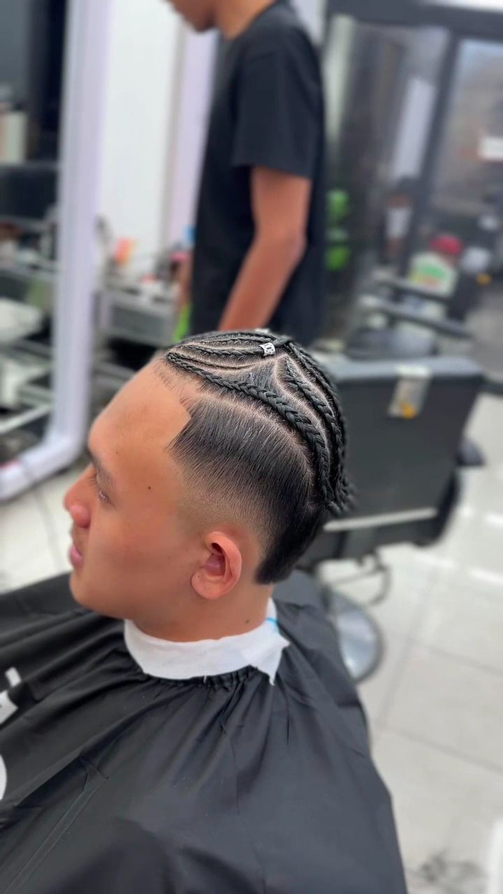 Detail kepang cornrow dan fade rapi pada sisi rambut pelanggan
